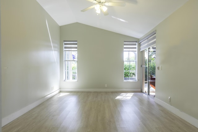 unfurnished room with lofted ceiling, light wood-style floors, ceiling fan, and baseboards