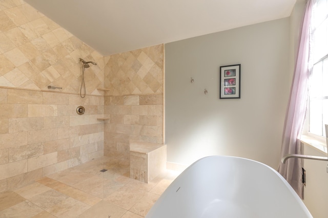 bathroom with a tile shower and a freestanding bath