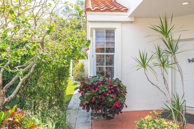 exterior space with a tiled roof and stucco siding