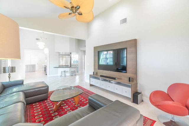 living area with high vaulted ceiling, a ceiling fan, visible vents, and light tile patterned floors