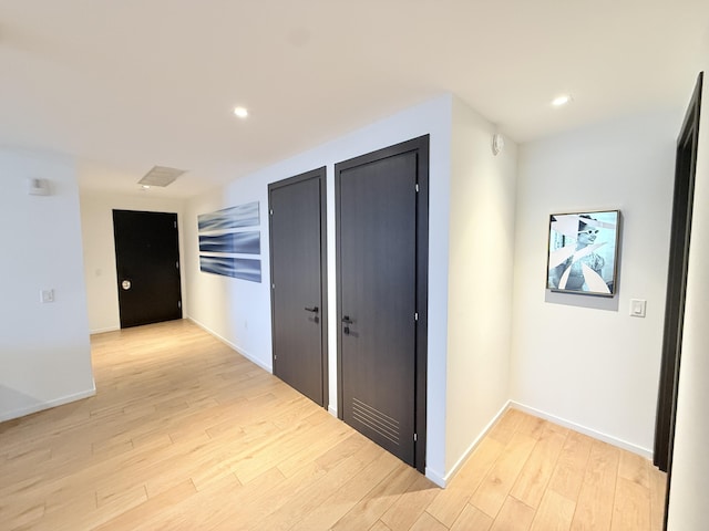 hallway with baseboards, light wood-type flooring, and recessed lighting