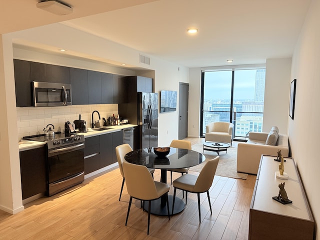 kitchen with stainless steel appliances, light countertops, visible vents, backsplash, and modern cabinets