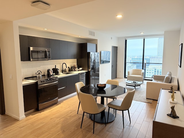 kitchen featuring light countertops, appliances with stainless steel finishes, modern cabinets, and backsplash