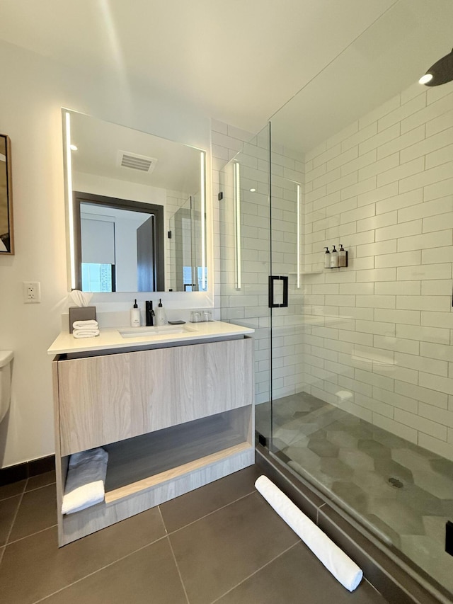 full bathroom featuring a stall shower, baseboards, visible vents, tile patterned floors, and vanity