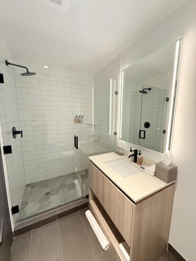 bathroom with a shower stall, vanity, and tile patterned floors