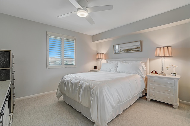 bedroom with ceiling fan, baseboards, and light colored carpet