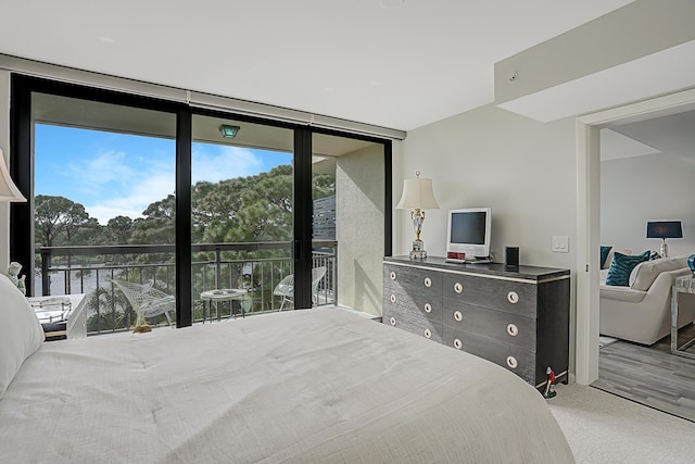 bedroom featuring expansive windows and carpet floors