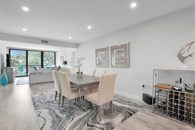 dining area with light wood-type flooring, baseboards, visible vents, and recessed lighting