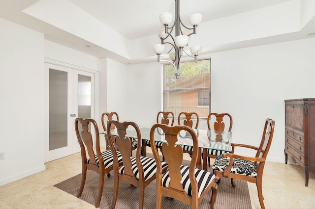 dining space featuring light tile patterned floors, baseboards, a raised ceiling, french doors, and a chandelier