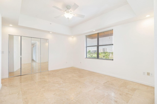 unfurnished room featuring a ceiling fan, recessed lighting, a raised ceiling, and baseboards