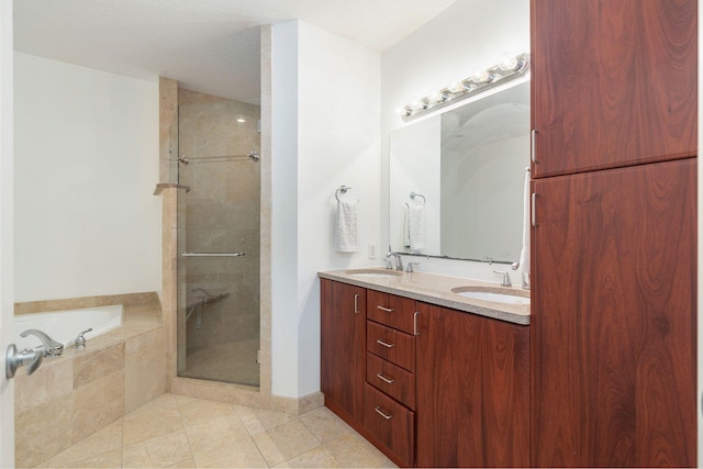 bathroom featuring tile patterned flooring, a sink, a bath, and a shower stall