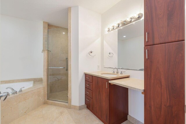 bathroom with a garden tub, a shower stall, tile patterned floors, and vanity