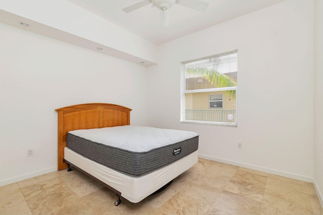 bedroom with a ceiling fan and baseboards