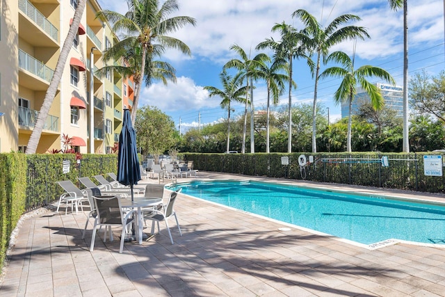 community pool featuring fence and a patio