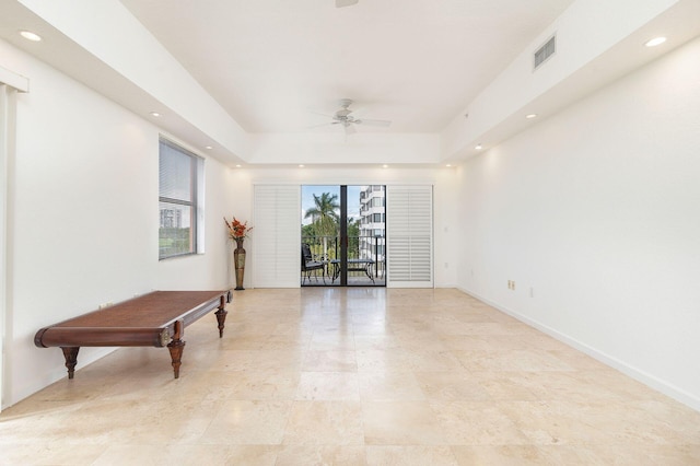 spare room with recessed lighting, a ceiling fan, visible vents, baseboards, and a raised ceiling