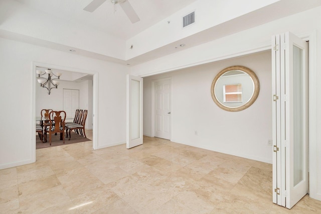 empty room with ceiling fan, visible vents, and baseboards