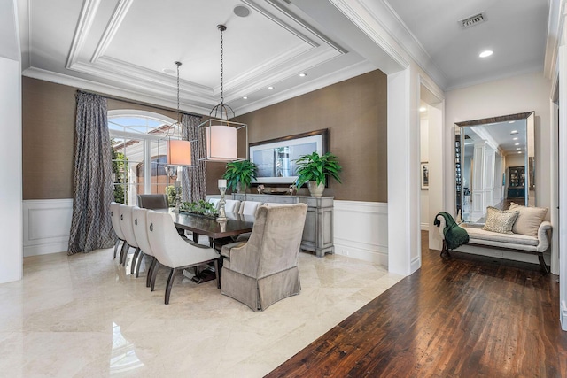 dining room with a wainscoted wall, crown molding, and visible vents