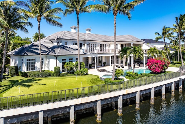 back of house with a fenced in pool, a water view, a fenced backyard, a balcony, and a patio area