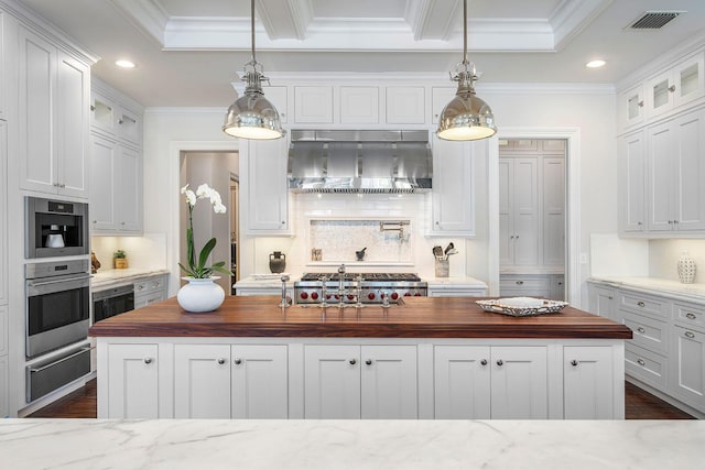 kitchen featuring visible vents, butcher block countertops, glass insert cabinets, a warming drawer, and wall chimney exhaust hood