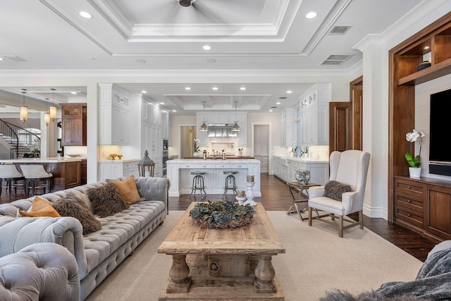 living room with visible vents, a raised ceiling, and dark wood-type flooring