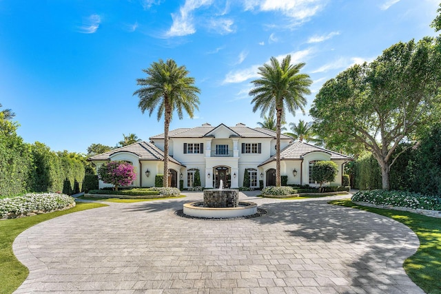 view of front facade with curved driveway and stucco siding