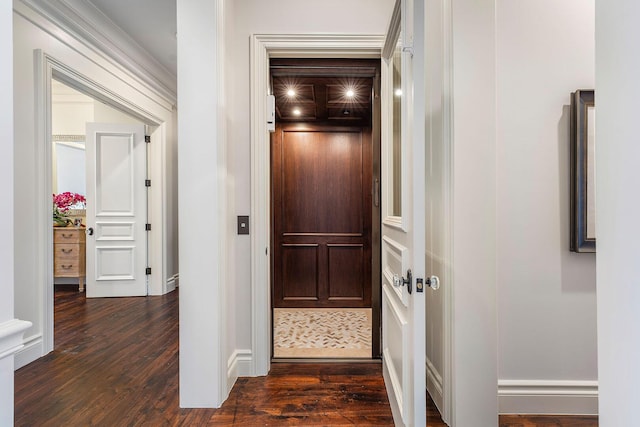 hallway featuring dark wood-type flooring, elevator, and baseboards