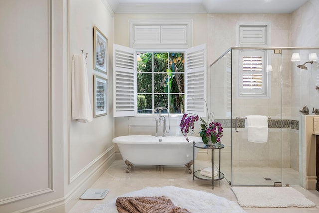 full bath featuring a soaking tub, a stall shower, baseboards, and ornamental molding