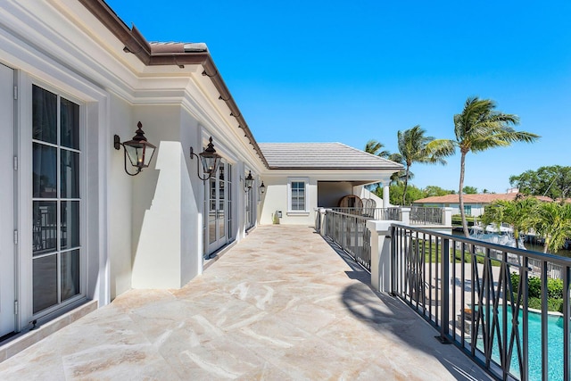 view of patio / terrace featuring a fenced in pool and a balcony