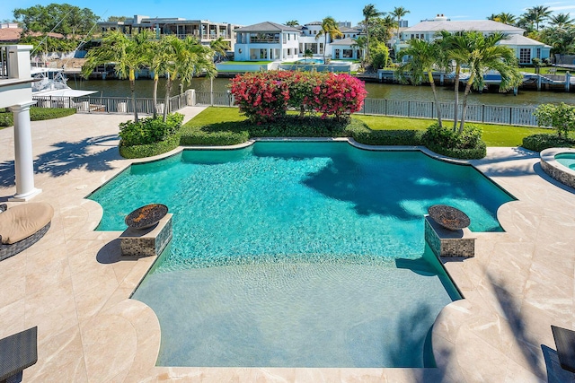 view of pool with a fenced in pool, a residential view, fence, and a water view