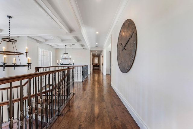 hallway featuring baseboards, beam ceiling, an inviting chandelier, coffered ceiling, and dark wood-style flooring