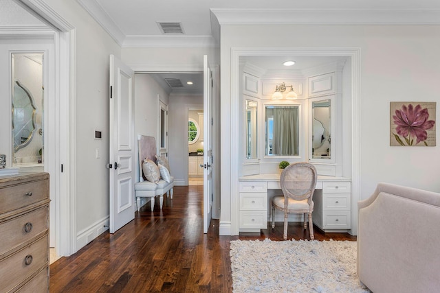 interior space featuring visible vents, dark wood-type flooring, built in desk, crown molding, and baseboards