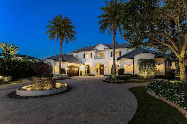 view of front of property featuring a garage, curved driveway, and stucco siding