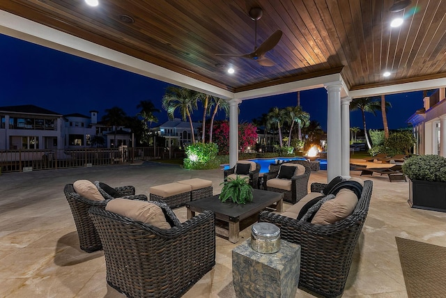 patio at twilight featuring an outdoor living space, ceiling fan, and fence