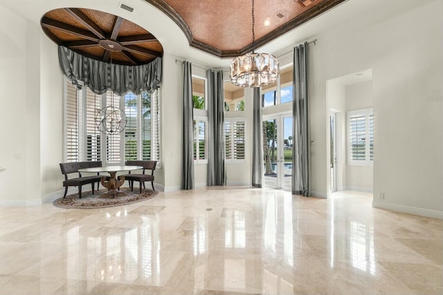 interior space featuring baseboards, marble finish floor, and an inviting chandelier