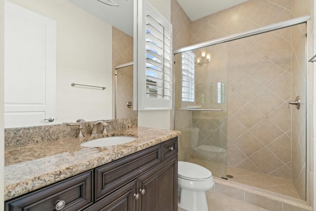 full bathroom featuring toilet, a shower stall, and vanity