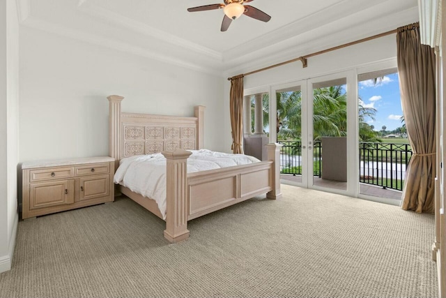 bedroom featuring ceiling fan, light colored carpet, access to exterior, french doors, and a raised ceiling