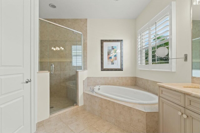 bathroom featuring a stall shower, tile patterned flooring, a garden tub, and vanity