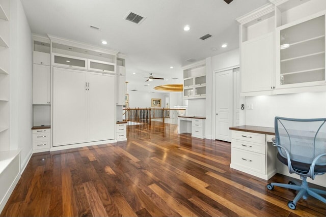 unfurnished office with visible vents, dark wood finished floors, built in desk, and recessed lighting