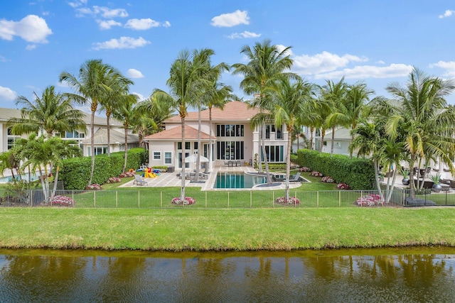 back of house featuring a fenced backyard, a patio, a water view, and a lawn