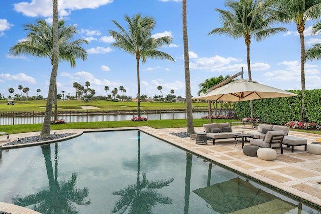 view of swimming pool with a patio area, a water view, fence, and an outdoor hangout area