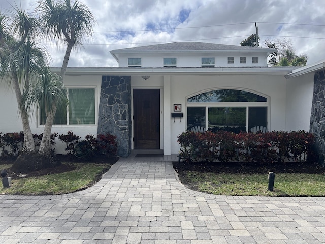 view of front facade with stone siding and stucco siding