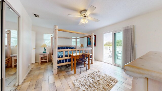 bedroom featuring beam ceiling, multiple windows, visible vents, and tile walls