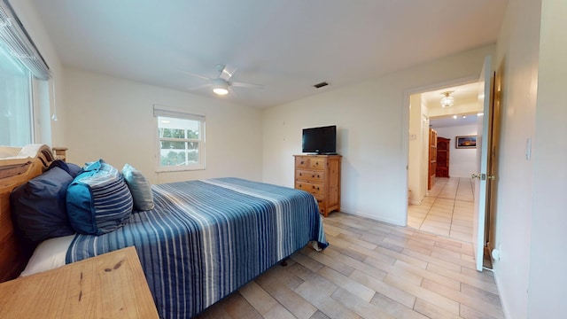 bedroom with a ceiling fan, visible vents, and wood finished floors