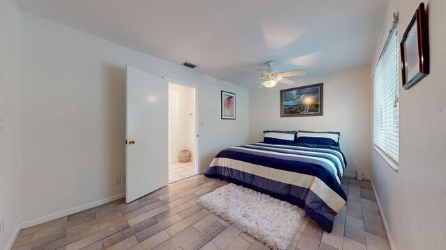 bedroom featuring a ceiling fan, a closet, multiple windows, and baseboards