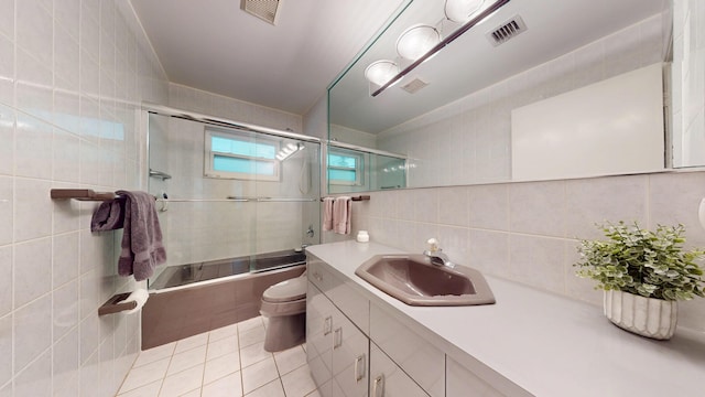 bathroom featuring toilet, visible vents, tile walls, and vanity