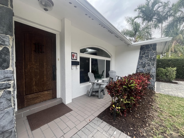 entrance to property featuring stucco siding