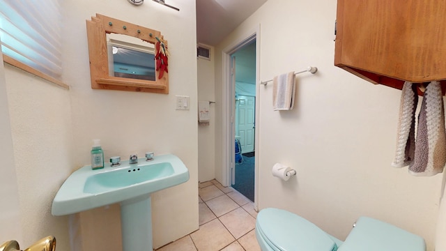 half bathroom featuring visible vents, toilet, and tile patterned floors