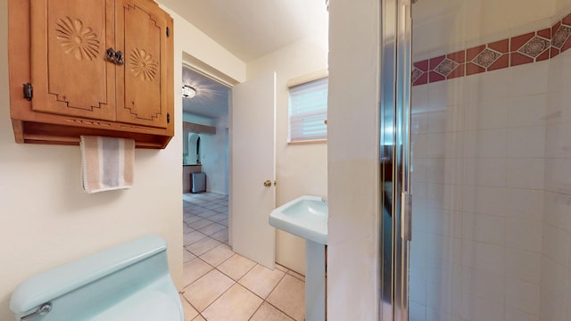 full bathroom with a shower stall, toilet, and tile patterned floors