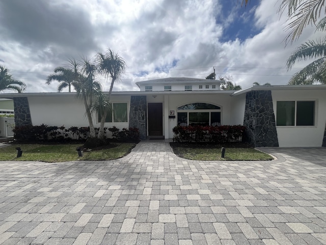 view of front of home featuring stone siding and stucco siding