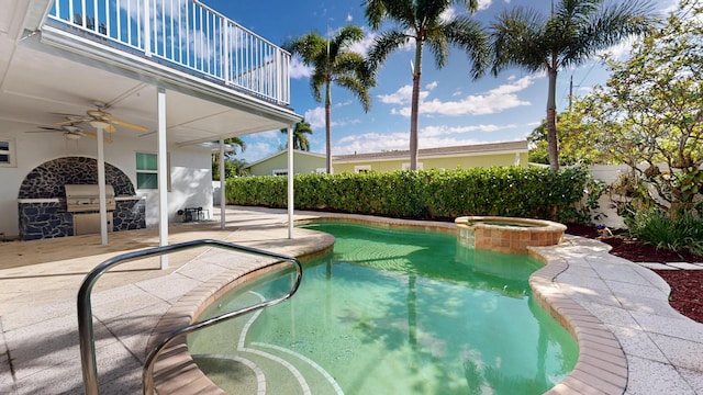 view of swimming pool featuring ceiling fan, an outdoor kitchen, fence, a pool with connected hot tub, and a patio area